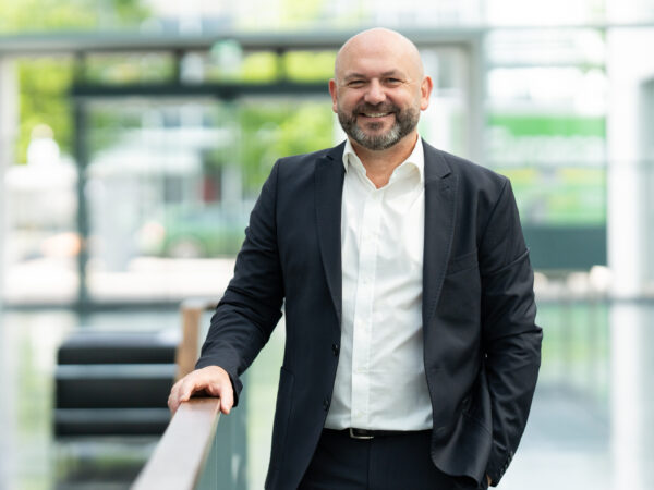 Header-Grafik: GF Markus Bockhorni steht an einem Treppengeländer