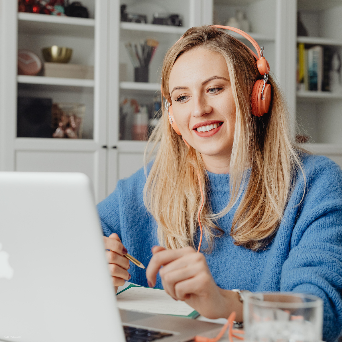 Blonde Frau am Laptop mit Kopfhörer beim zuhören eines Online-Seminars