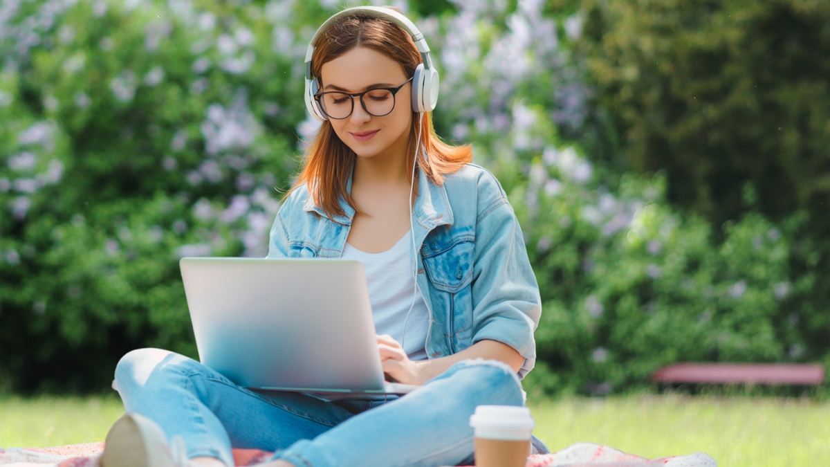 Frau beim Online-Lernen mit Laptop im Freien
