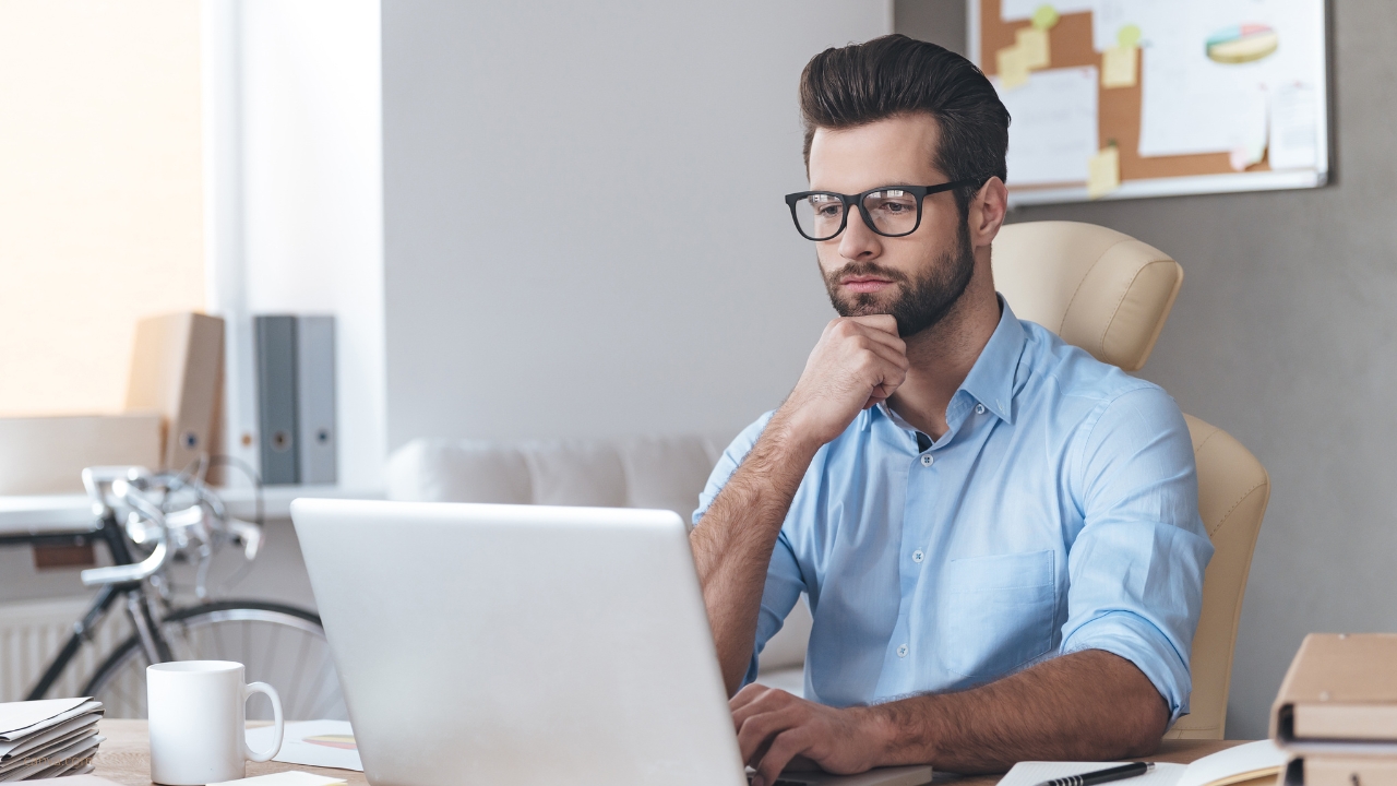 Mann am Schreibtisch mit Laptop bei der Arbeit