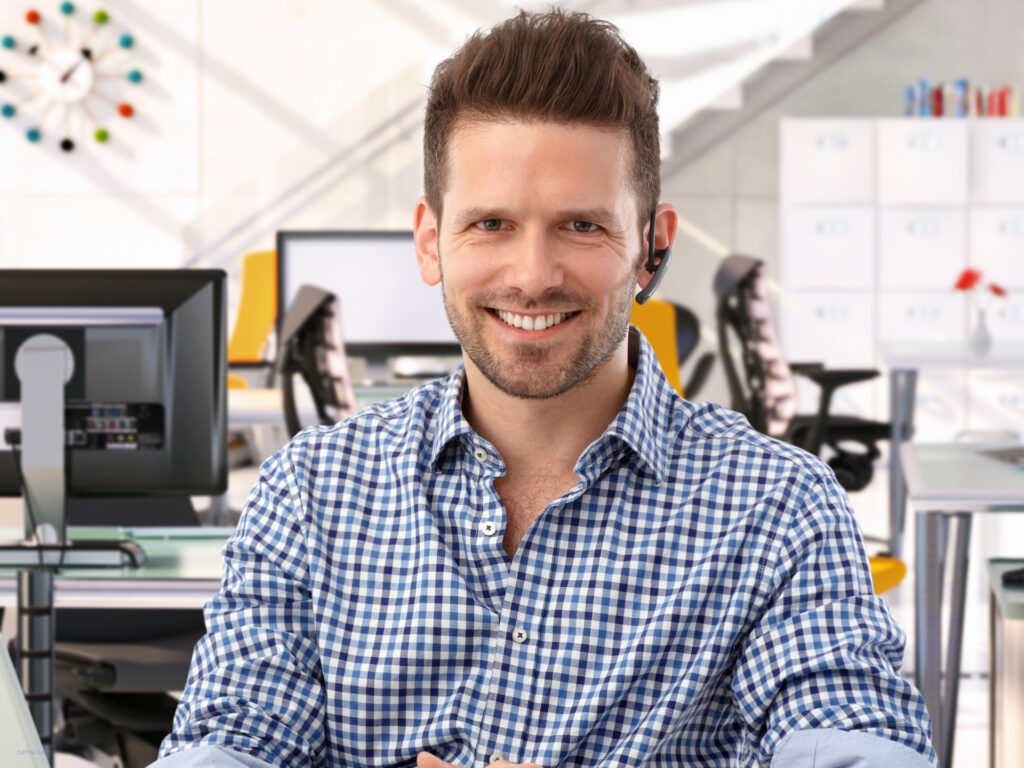 Mann aus dem Marketing lächelt im modernen Büro