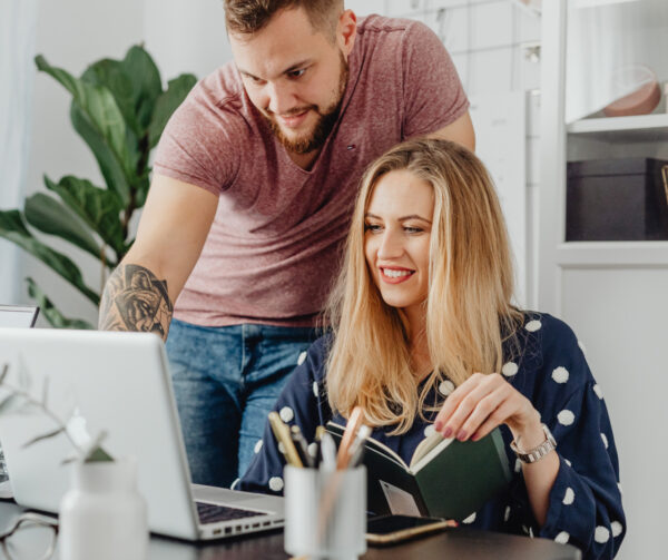 Lächelnder Mann und Frau am Schreibtisch mit Laptop bei der Arbeit